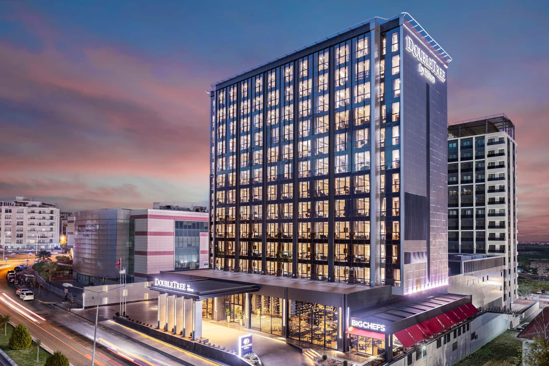 The illuminated exterior of DoubleTree by Hilton Şanlıurfa at dusk
