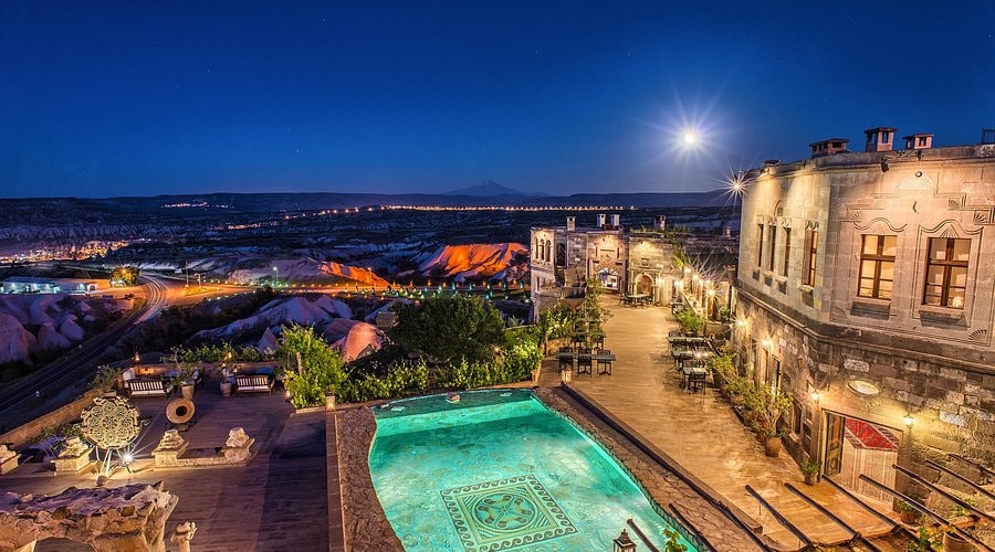 The illuminated stone terraces and pool of Museum Hotel above the Cappadocia valley at night