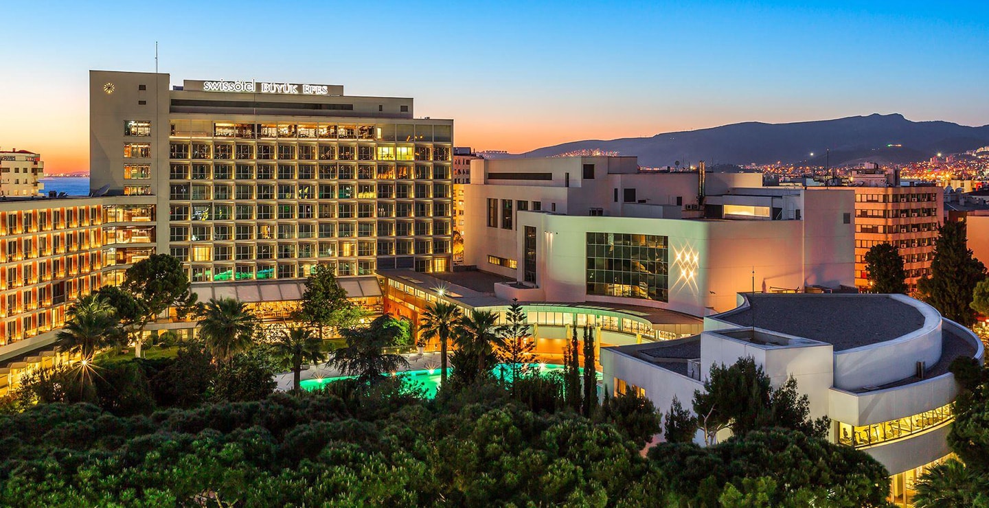 The illuminated gardens and pool of Swissôtel Büyük Efes in İzmir at dusk
