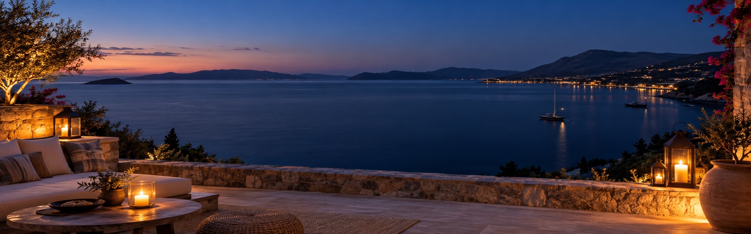 A quiet lantern-lit terrace above a calm Aegean bay at blue hour