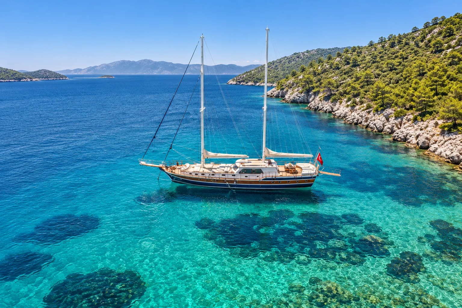 A traditional wooden gulet anchored in a turquoise cove on the Turkish coast