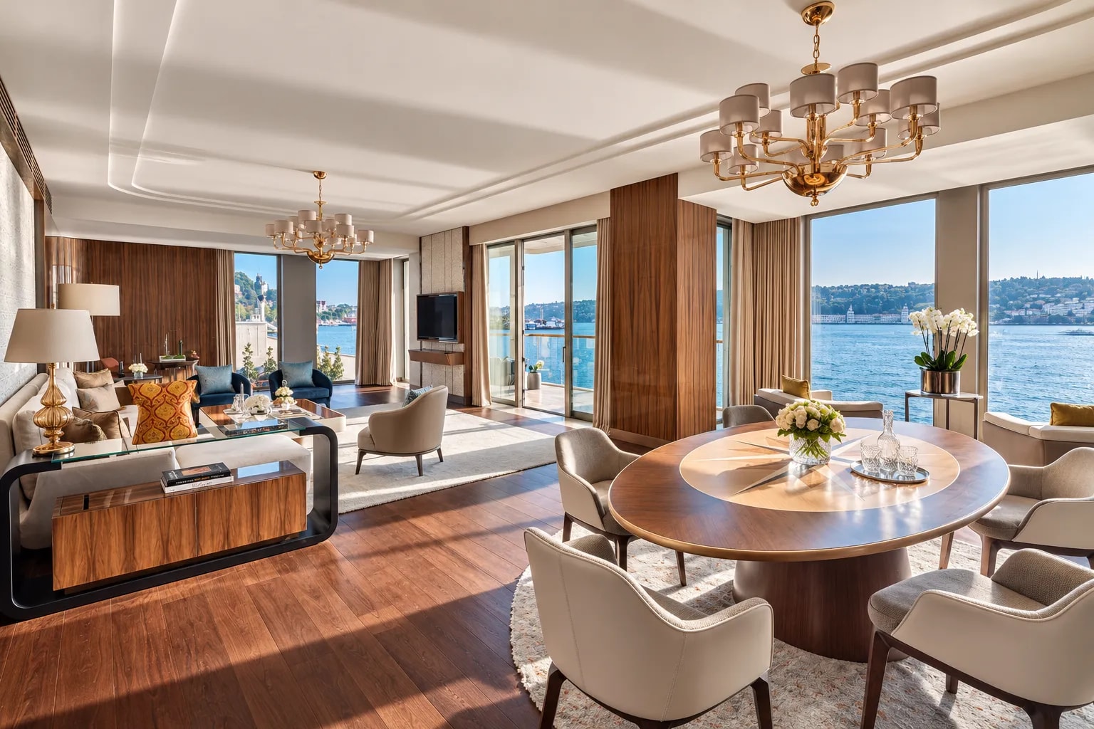 A sunlit hotel suite with walnut panelling, a round dining table and a view of the Bosphorus