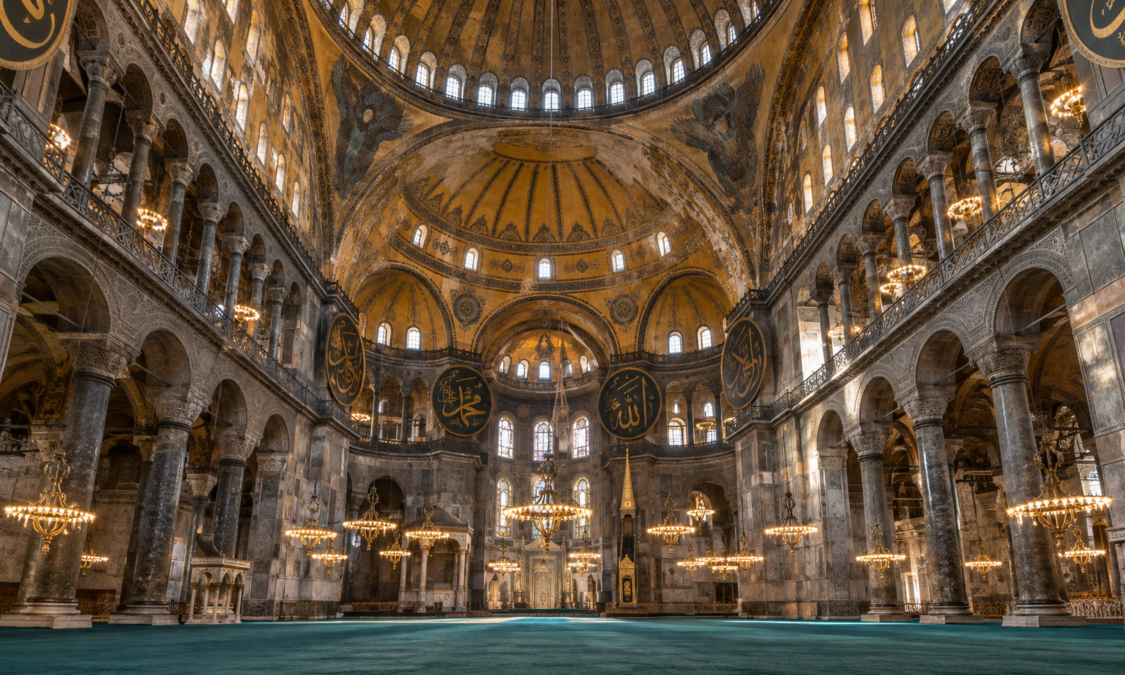 The vast domed interior of a Byzantine-era mosque with large calligraphy roundels and hanging chandeliers