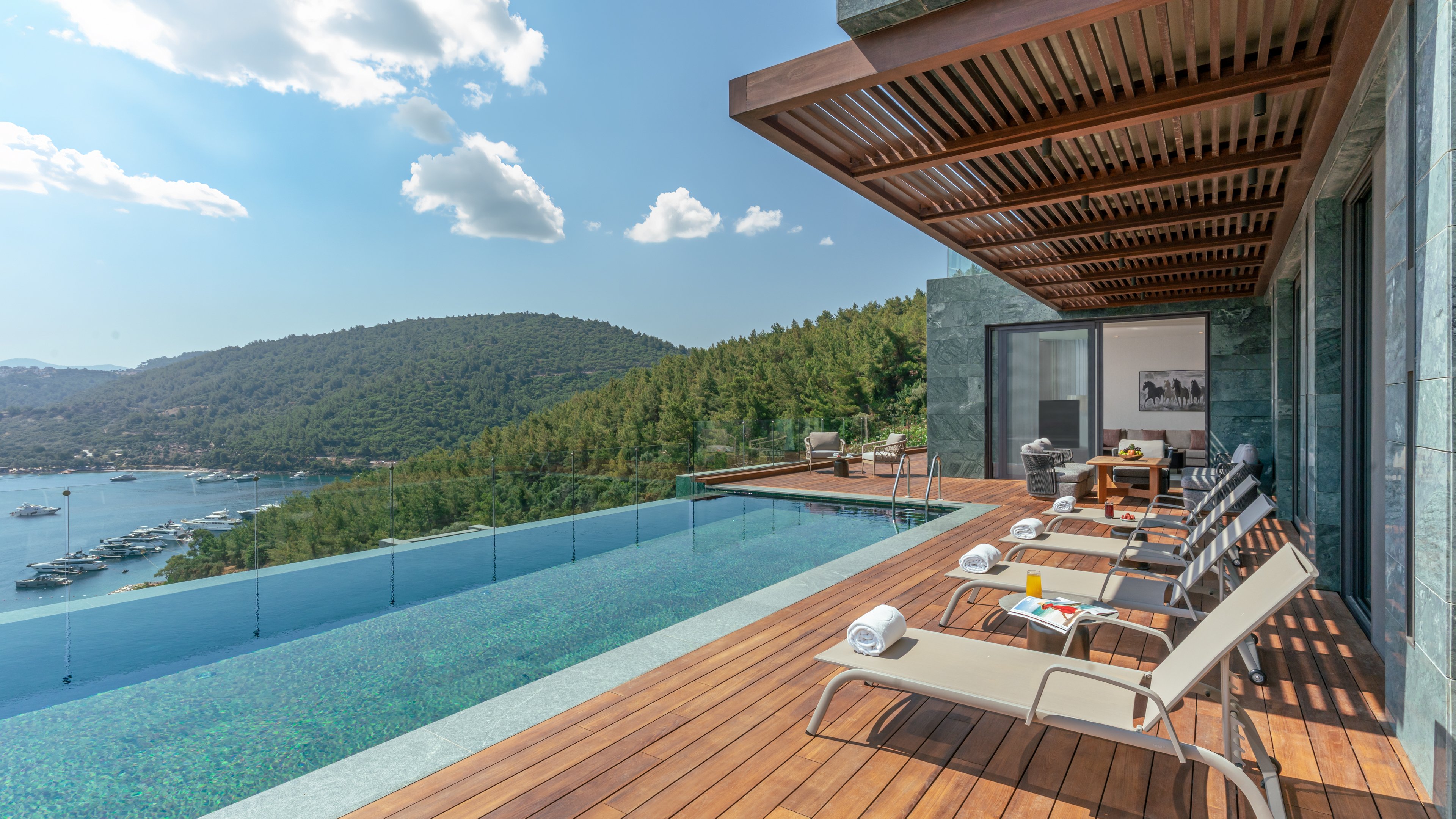 A terrace infinity pool at a villa of Mandarin Oriental, Bodrum, looking over a green bay