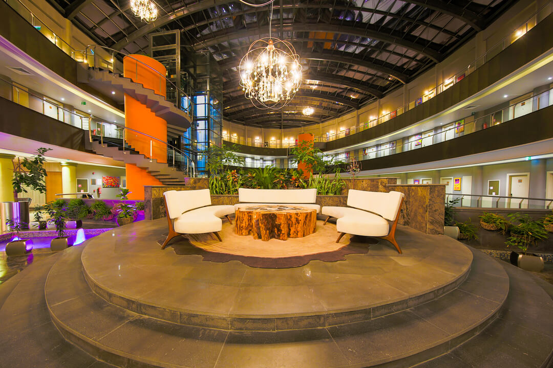 The glass-roofed atrium of Doğa Thermal Health & Spa with a round lounge and chandelier